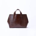 A dark brown crocodile-embossed leather handbag with dual top handles, centered on a clean white background.