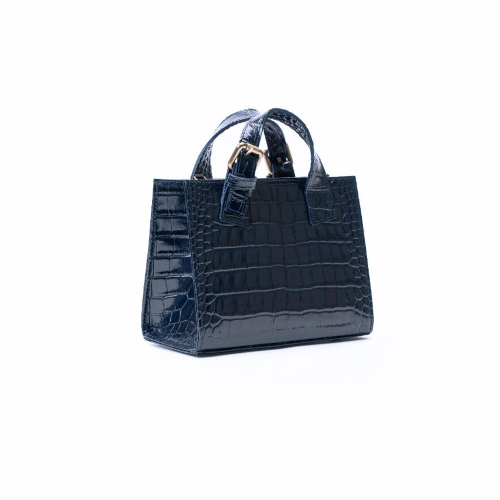 A dark navy blue crocodile-embossed leather handbag with double top handles and gold-tone hardware, shown against a plain white background.